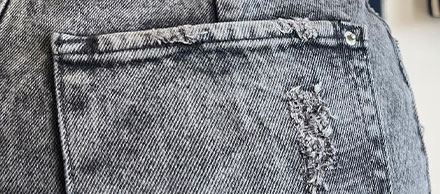 Primer plano de pantalón vaquero desgastado con rasgón