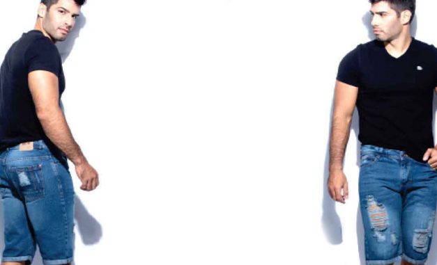 Modelo hombre en jeans rotos y camiseta negra